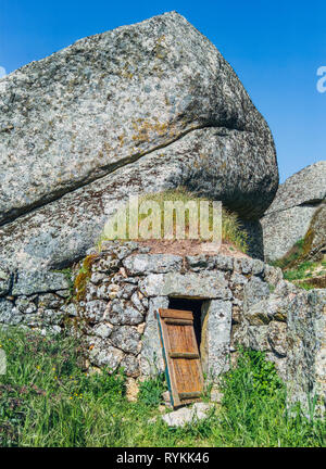 Ein prähistorisches Felssteinhaus in Monsanto, Portugal. Eine überwuchert Gruta: Eine Höhle, die einst als Trinkhöhle diente. Interessante Architektur. Portugal, Europa Stockfoto