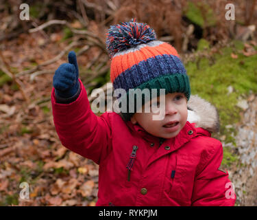 Kleine Jungen im roten Mantel und Bobble hat den Daumen nach oben anmelden Stockfoto