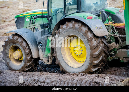 John Deere Traktor in ein schlammiges Feld. Stockfoto