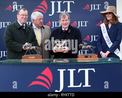 J. S. McManus (Mitte) während der Präsentation nach Sieg in der Jlt Novizen "Chase mit Defi Du Seuill geritten von Barry Geraghty während der St Patrick's Donnerstag der2019 Cheltenham Festival in Cheltenham Racecourse. Stockfoto