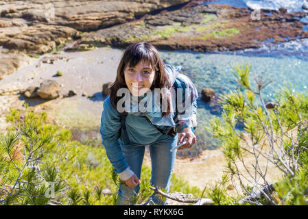 Oben Blick auf junge Frau legere Kleidung am Strand, während die Kamera in einem hellen Tag suchen Stockfoto