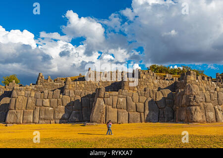 Ein paar Fuß entlang der riesigen Granit inca Wand von Sacsayhuaman in Cusco bei Sonnenuntergang, Peru. Stockfoto