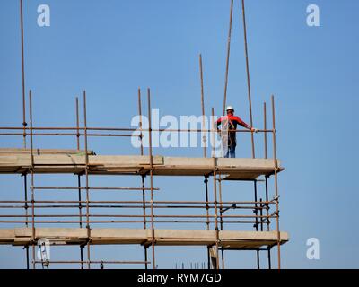 Nicht erkennbare Bauarbeiter auf der Baustelle Gerüste Stockfoto