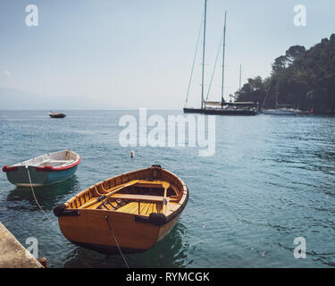 Zwei hölzerne Fischerboote in kleinen Jachthafen am Mittelmeer Dorf in Italien günstig auf dem Hintergrund von Segelbooten und Seascape. Stockfoto