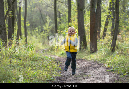 Junge verläuft entlang einer Forststraße auf einem Sommer sonnigen Tag Stockfoto