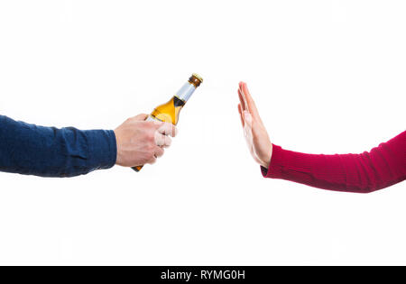 Nahaufnahme der männlichen Händen hält eine Flasche Bier und schlägt vor, es mit einer Frau auf weißem Hintergrund. Menschlichen arm Weigerung, Geste, Ablehnen von Alkohol, Stockfoto