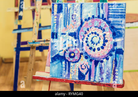 Malerei auf einer Staffelei in einer Art Studio. Abstrakte Malerei in Acryl auf Leinwand. Stockfoto