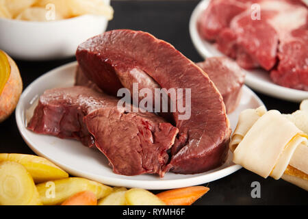 Stücke von rohem Rindfleisch Herzmuskel in Nahaufnahme. Zutaten für die Zubereitung von gesunder Nahrung für Hunde Stockfoto