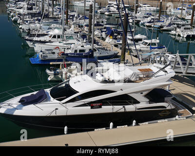 Weiß und Marineblau Vergnügen Boote in Elizabeth, Marina, St Helier, Jersey, Channel Islands. Stockfoto