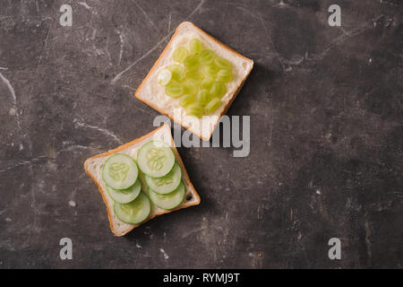 Avocado Sandwich auf dunkles Brot mit frischen in Scheiben geschnittenen Avocados aus oben Stockfoto