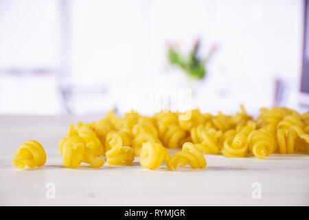 Menge ganze rohe Nudeln funghetto Sorte mit Blumen in einem weißen Küche Stockfoto