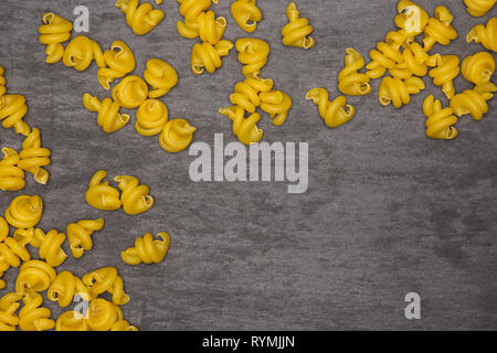 Menge ganze rohe Nudeln funghetto Vielzahl copyspace flatlay am grauen Stein Stockfoto