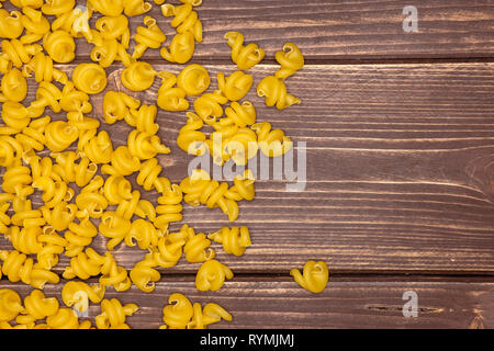 Menge ganze rohe Nudeln funghetto Vielzahl flatlay auf braunem Holz Stockfoto