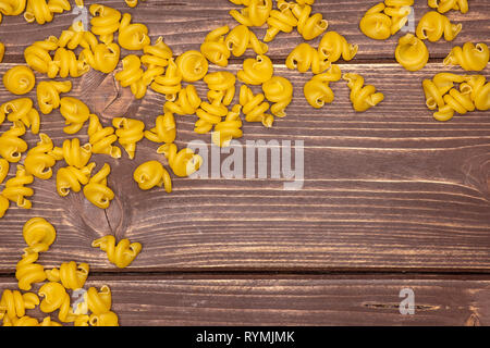 Menge ganze rohe Nudeln funghetto Vielzahl copyspace flatlay auf braunem Holz Stockfoto