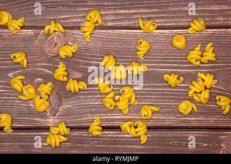 Menge Weizen rohe Nudeln funghetto Vielzahl flatlay auf braunem Holz Stockfoto