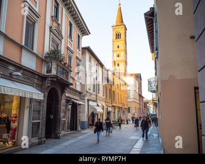 PAVIA, Italien - 22. FEBRUAR 2019: die Menschen auf der Straße Via XX Settembre und Blick auf den Glockenturm der Kirche Chiesa di Santa Maria del Carmine in Pavia Stadt i Stockfoto