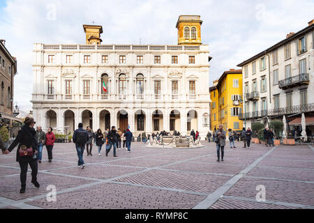 BERGAMO, Italien - 23. FEBRUAR 2019: Touristen auf der Piazza Vecchia Square und Ansicht des Palazzo Nuova (öffentliche Bibliothek Biblioteca Civica Angelo Mai) in Citta Stockfoto