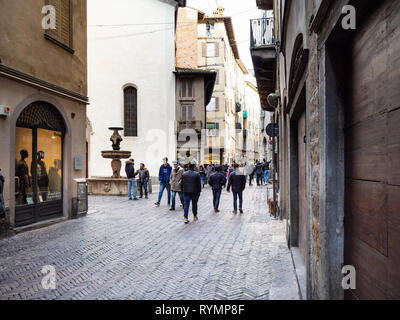 BERGAMO, Italien - 23. FEBRUAR 2019: Menschen gehen auf die Straße Via Gombito in der Nähe von Brunnen Fontana del Gombito (Fontana di San Pancrazio) in Citta Alta (Uppe Stockfoto