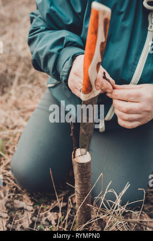 Eine Frau schneidet einen jungen Baum mit einem Messer für die Beimpfung der Obst Zweig Stockfoto