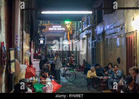 Ho Chi Minh City, Vietnam: eine dunkle Gasse, die nach Saigon Centre Hostel den Gang entlang durch vietnamesische Volk Getränke mit an den Tischen genommen führt. Stockfoto