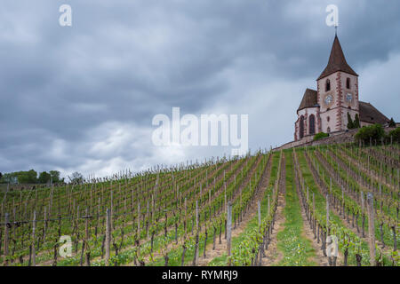 Stürmischen Himmel über Hunawihr Dorf Kirche im Elsass, Frankreich. Stockfoto