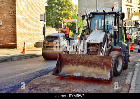 Straße resurfacing Bagger Lader und Walze über dies und Asphalt nach surfacing Maschine Stockfoto