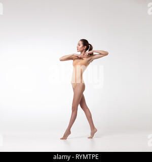 Junge schöne Tänzerin in beige Badeanzug Stockfoto