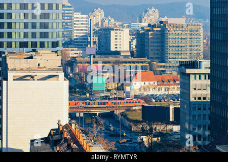 Besetzt die moderne Innenstadt mit dem Zug über die Brücke und Altstadt Architektur in Ljubljana in Slowenien im Winter. Blick auf die Stadt. Cityscap Stockfoto