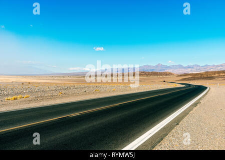 Desert Highway durch karge Land führenden unter blauem Himmel. Stockfoto
