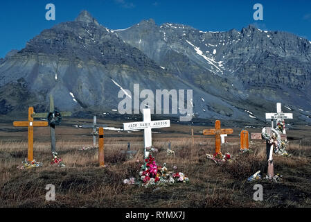 Hölzerne Kreuze markieren die Gräber von Native Alaskans in Anaktuvuk Pass, die letzte verbleibende Lösung des Nunamiut Menschen (Eskimos) in Alaska, USA begraben. Die abgelegene Dorf hat eine Bevölkerung von weniger als 400 und ist oberhalb des Polarkreises gelegen und in den Toren der Arctic National Park. In der Nähe von den baumlosen Bergen der Brooks Range gelegen, Anaktuvuk Pass ist für eine Migration Route für karibus (Rentiere), das wilde Tier, das wesentliche Existenzgrundlage der kleinen Gemeinschaft bietet. Stockfoto