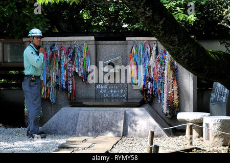UENO PARK, Tokyo, Japan - 9. Juli 2018: einem Arbeitnehmer stand neben der CND Peace Monument in Ueno Park während Fasten seinen Helm in Toyko Japan Stockfoto