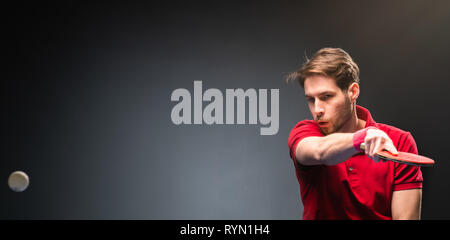 Hübscher junger Mann spielt Ping pong Tischtennis Hallenbad Stockfoto
