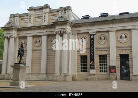 Sir Walter Raleigh Statue vor Pepys Gebäude, Büsten von admirals im Old Royal Naval College in Greenwich, London, UK geformt hat. Stockfoto