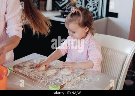 Adorable Kid Kochen mit Mama in der Küche. Stockfoto