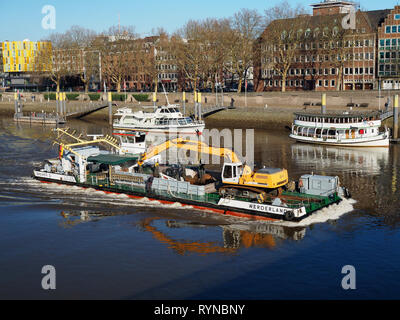 Bremen, Deutschland - 14. Februar 2019 - binnenschiff Transportieren eines Schwimmbaggers an der Weser mit waterfront Gebäude und Riverside Promenade im Hinterg Stockfoto