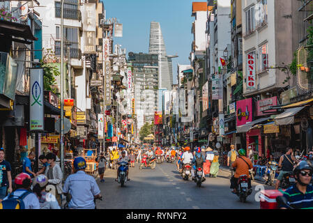 Ho Chi Minh, Vietnam - Januar 7, 2019: Bui Vien Street mit Menschen und Straßenverkehr überfüllt, seine zahlreichen Tafeln & Bitexco Financial Tower. Stockfoto