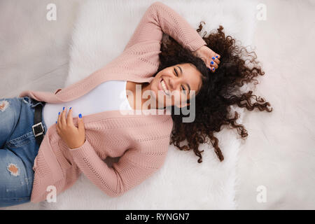 Attraktive Biracial an der High School zur Festlegung auf dem Boden lachen und posieren für Studio Porträts Stockfoto