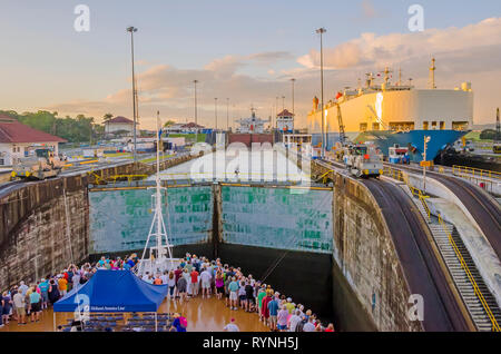 Panama Canal Cruise Ship Passagiere auf dem Schiff Bug kommen an Gatun Locks Eintrag kurz nach Sonnenaufgang Stockfoto