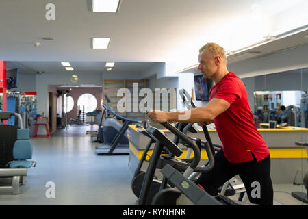 Mann Training in einem Fitnessstudio. Passen junge Mann in Sportkleidung, arbeiten allein in der Turnhalle Stockfoto