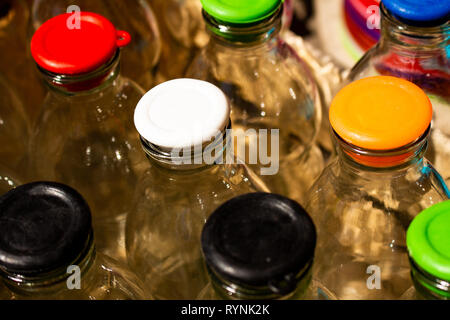 Mehrere transparente Gläser mit farbigen Deckeln. Behälter hermetisch zu speichern. Stockfoto