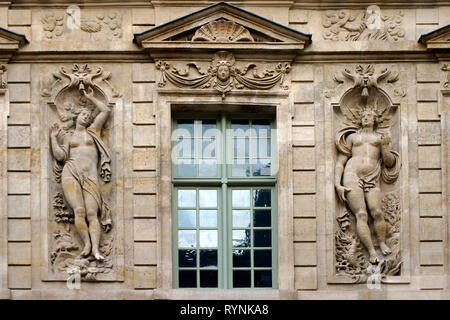 Die plastischen Reliefs von zwei griechisch-römischen Zahlen auf der Fassade eines alten Hauses in Paris. Stockfoto