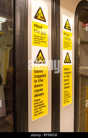Mind The Gap Gefahr Warnschild auf der Innenraum eines geschlossenen Londoner Tube Schlitten Tür Stockfoto