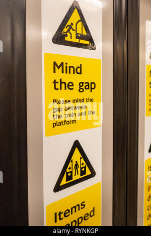 Mind The Gap Gefahr Warnschild auf der Innenraum eines geschlossenen Londoner Tube Schlitten Tür Stockfoto