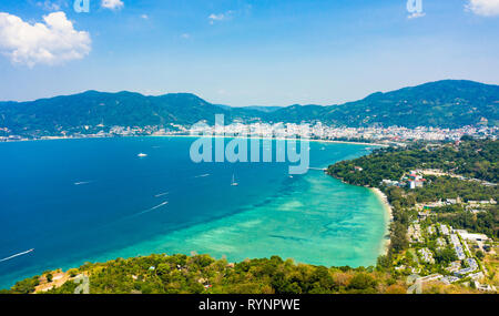 Ansicht von oben, beeindruckende Luftaufnahme von Patong City Skyline in der Entfernung und der schönen Tri Trang Strand gebadet durch ein Türkis und klaren Meer. Stockfoto