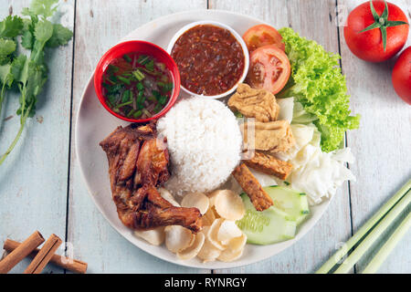 Nasi Lemak kukus mit gebratenen Drumstick, beliebten traditionellen malaysischen lokalen Essen. Flach nach oben Ansicht von oben. Stockfoto