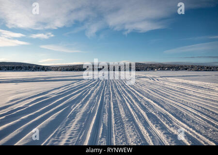 Spuren im Schnee auf dem gefrorenen See InarijÃ¤rvi in Inari, Finnland Stockfoto