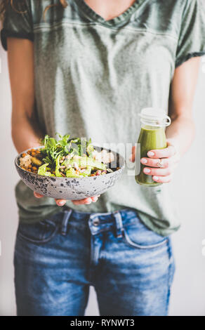 Frau in Jeans halten gesund Superbowl und Smoothie in Händen Stockfoto