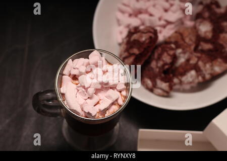 Hot Drink in ein Glas Schale mit rosa Marshmallows und White Box mit transparentem Deckel in der Form von Herzen mit Cookies Stockfoto