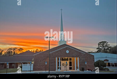 Sonntag abend sonnenuntergang Farben sorgen für eine bunte Kulisse zu einem North Florida Baptist Church. Stockfoto