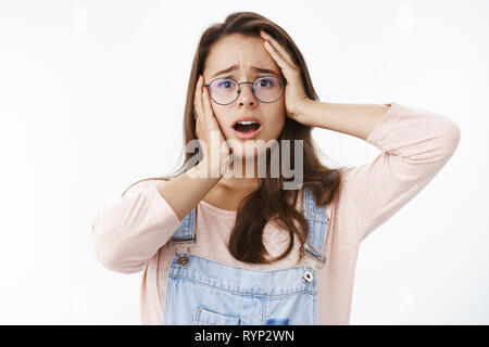 Taille- schuss besorgt Weiblich brunette Gefühl der Empathie und Schock offenen Mund und Stirn in Verzweiflung, Hände auf den Kopf erleben schreckliche Stockfoto